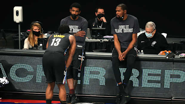 Brooklyn Nets point guard Kyrie Irving (C) and power forward Kevin Durant (R) talk to shooting guard James Harden (13)